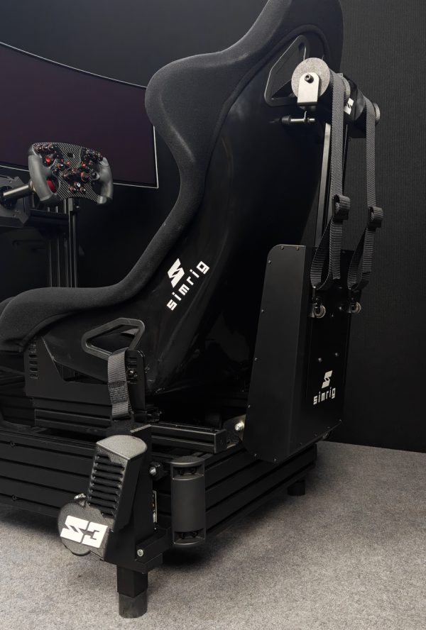 De SBM gemonteerd achter een racestoel op een SIMRIG SR3 rig, de schouderbanden over zijn rollers