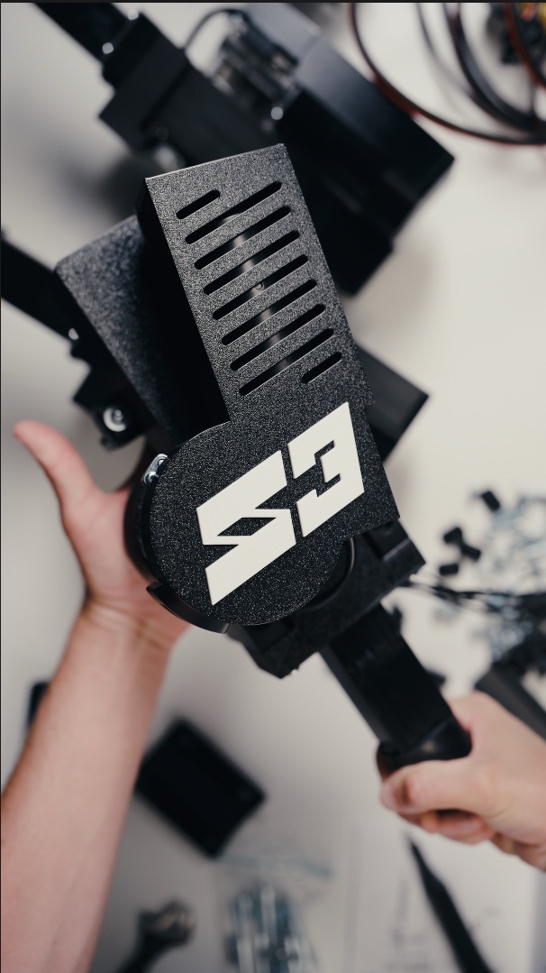 Un attuatore SIMRIG SR3 tenuto con entrambe le mani al banco di assemblaggio