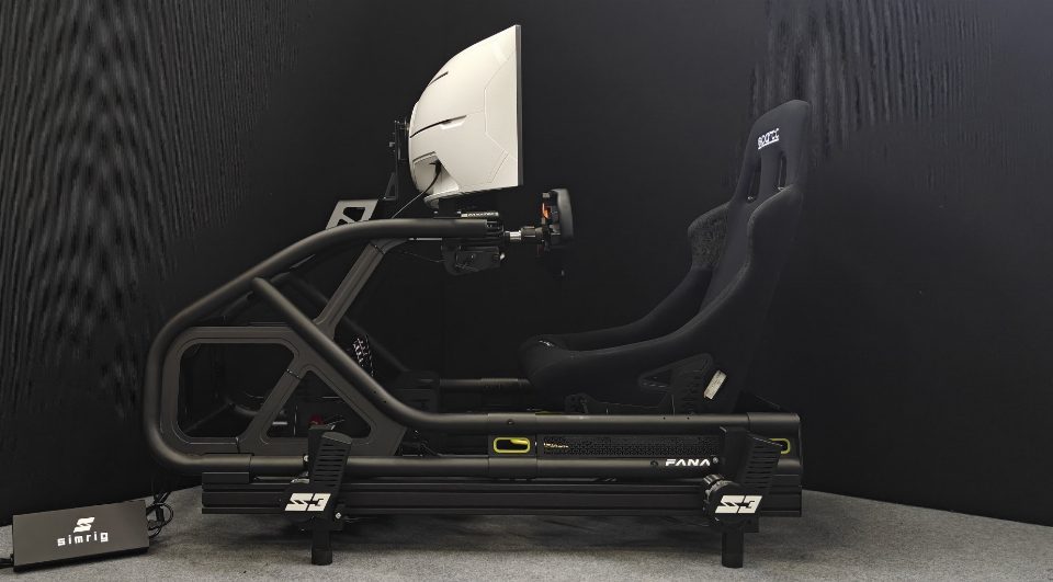 Un sistema di movimento SIMRIG SR3 sotto un rig per sim racing tubolare, visto di lato